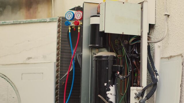 Close up zoom in shot of manifold meters inside opened faulty air conditoner. Set of barometer benchmarking hvac system component used for checking air conditioner refrigerant in need of maintenance