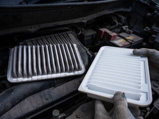 The master changes the air filter in the car engine. 