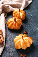 Tasty pumpkin shaped buns on black background