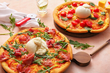 Wooden boards of tasty pizzas with Burrata cheese on beige background