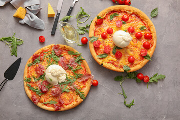 Tasty pizzas with Burrata cheese on grey background