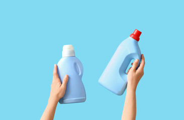 Woman with bottles of detergent on blue background