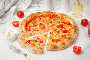 Tasty pizza Margarita with tomatoes and bowl of mozzarella on white table