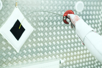 Professional fencer girl with fencing mask and rapier. Training in hall 