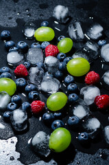 berries with ice cubes on a black background
