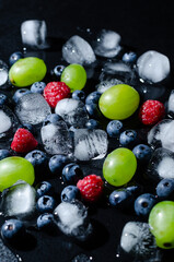berries with ice cubes on a black background
