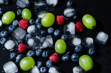 berries with ice cubes on a black background