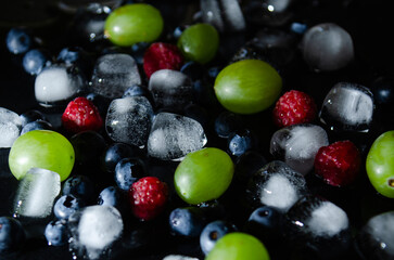 berries with ice cubes on a black background