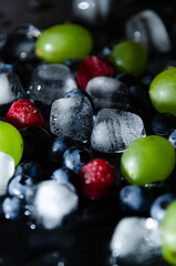berries with ice cubes on a black background