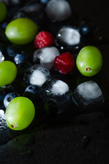 berries with ice cubes on a black background