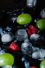 berries with ice cubes on a black background