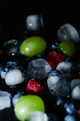berries with ice cubes on a black background