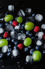 berries with ice cubes on a black background
