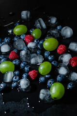 berries with ice cubes on a black background