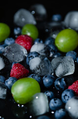 berries with ice cubes on a black background