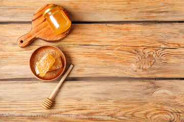 Obraz na płótnie Canvas Jar of tasty honey, dipper and combs on wooden background