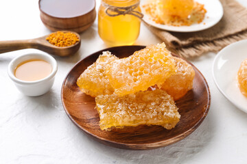 Plate with sweet honeycombs on white background