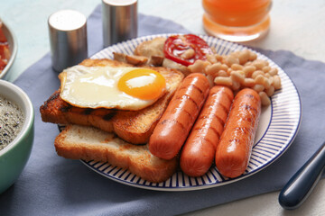 Plate of tasty English breakfast with fried egg on table