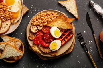 Plates of tasty English breakfast with eggs on black background