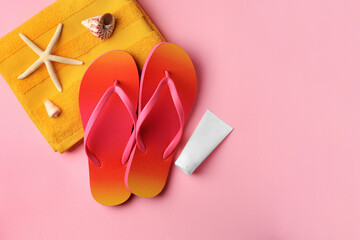 Sunscreen and beach accessories on pink background, flat lay with space for text