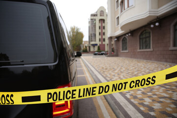 Yellow crime scene tape near car outdoors