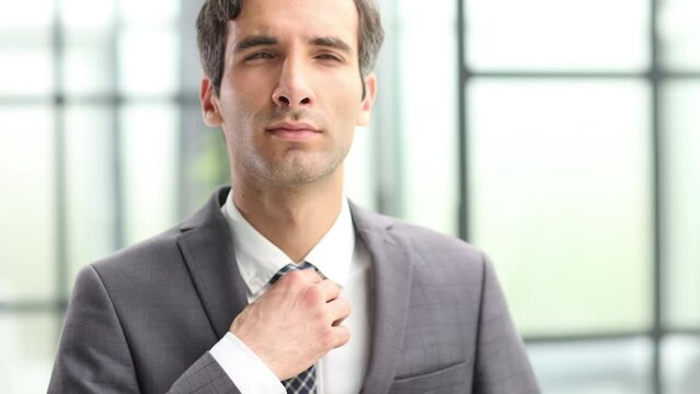 happy young businessman pulling his tie feeling good. I need fresh air.