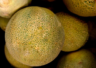 Fresh cantaloupes on the market filling the frame.