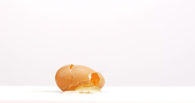 Fresh chicken egg crashes on the table white background.