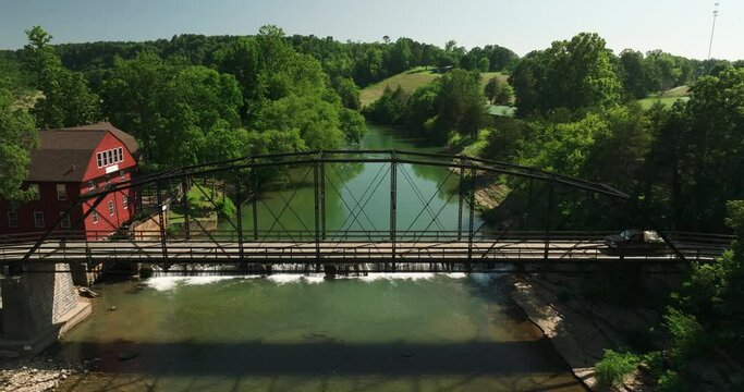 Historic steel truss bridge over mirror-like creek, War Eagle Mill, Arkansas