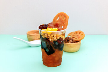 Cold assorted beans in syrup in transparent glasses with silver spoon on white background. This is one kind of delicious chinese traditional dessert. kind of Chinese dessert