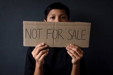 Human trafficking Awareness Day. Kid holding board with text Not for sale. Stop human trafficking campaign.