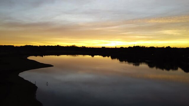 Calm, tranquil waters reflect the yellow sunlight as the sunsets in Mechels Broek.