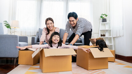 Asian family father mother daughter girl packing cardboard box relocation moving to new house, online marketing e-commerce unpacking stuff belongings home delivery. Lifestyle asian family together