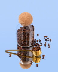 Fresh organic coffee beans in a glass jar with a round cork lid and coffee spoon. Coffee beans...