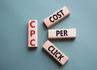 CPC - Cost Per Click symbol. Concept word AGM on wooden cubes. Beautiful grey green background....