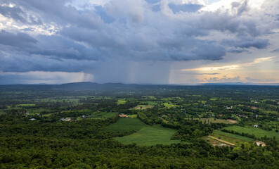Aerial view of rain over rural fields next to the Mekong River in Mukdahan province, Thailand.