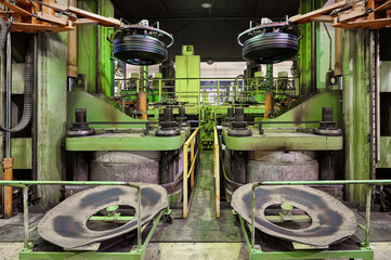 Automatic manipulators carry raw tire to vulcanization press