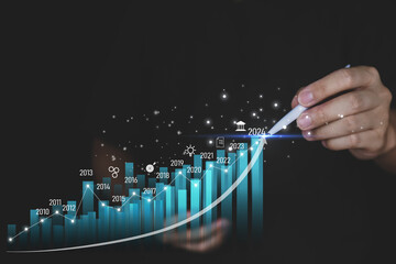 Concept business growing graph, chart with company progress and growth by year, 2024, economic growth, Business people check and analytic data of Annual Economic Growth Data. Digital screen touch.