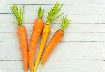 Organic carrots on a rustic wooden background close-up. Top view of organic vegetables.