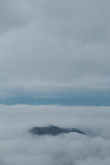 Fototapeta na wymiar Mountain range with visible silhouettes through the morning blue fog.