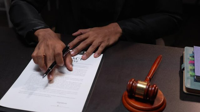 The lawyer working with a client discussing contract paper, a Business lawyer working about legal legislation in the courtroom to help their customer	