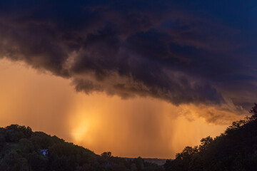 Dramatic storm clouds  with an intense rain lit by the setting sun, Croatia