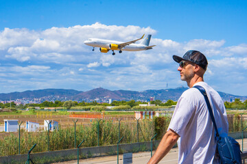 Man in a Cap Watching Airplanes with Enthusiasm at the Airport