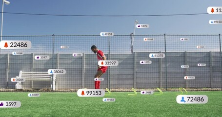 Animation of social media icons over african american male soccer player training on sports field - Powered by Adobe