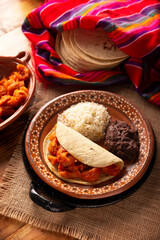 Chicharron en salsa roja. Pork rinds stewed in red sauce accompanied by rice and refried beans....