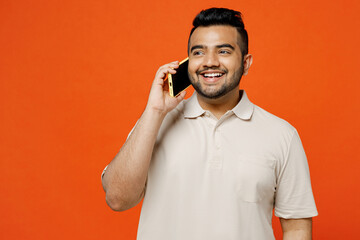 Young fun Indian man he wears white t-shirt casual clothes talk speak on mobile cell phone...