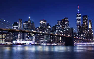 Night view of Manhattan from Brooklyn. Brooklyn bridge and skyscrapers in the background. New York City Skyline.