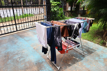 Wet clothes hanging on drying rack at the yard.