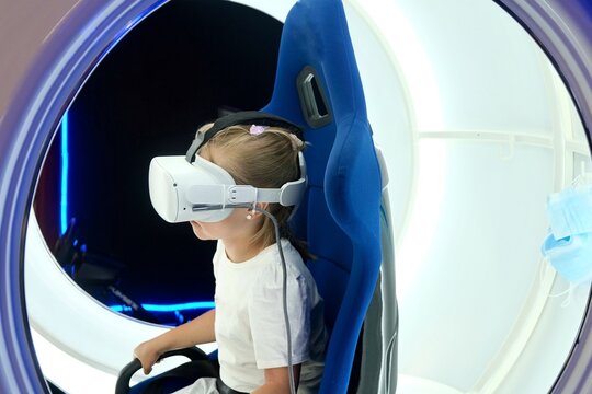 A little girl is playing a VR game in a capsule. VR glasses. Watch a movie, clip in VR glasses