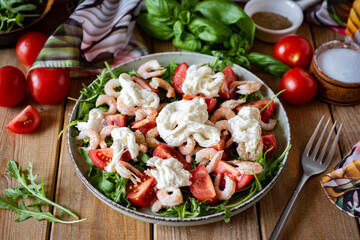 Breakfast for the whole family: salad with shrimp, spinach, cherry tomatoes, arugula and olive oil. Salad with tomatoes, shrimp and arugula for lunch. Close-up